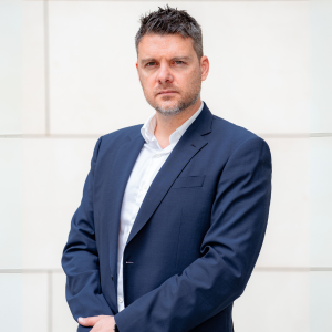 Dr. Stavros Kardahakis, Vice President of Professional Services, Serious, clean background