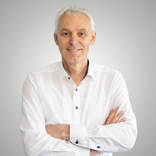 Hans-Ulrich Seufert, SVP of Product Development, smiling in a white shirt