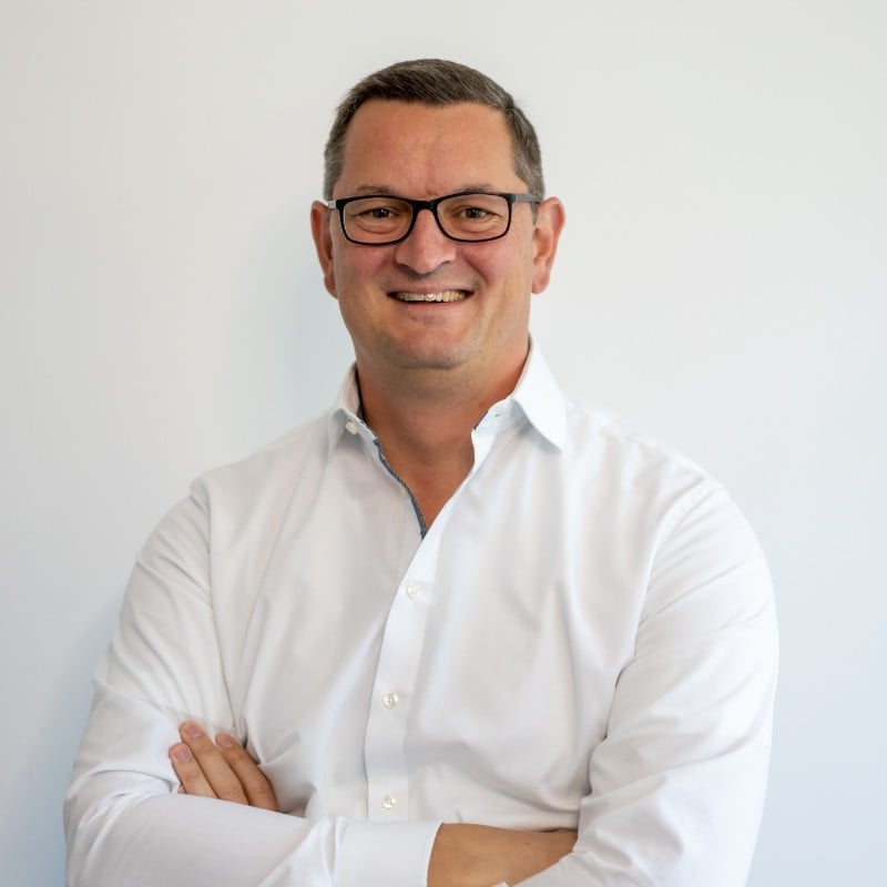 Martin Schmid, CEO of EXTEDO, smiling in a white shirt